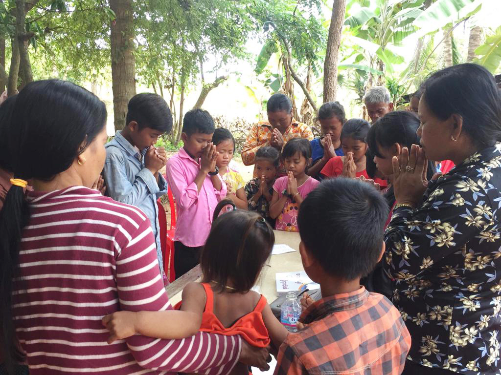 Adults and children gathered for prayer.